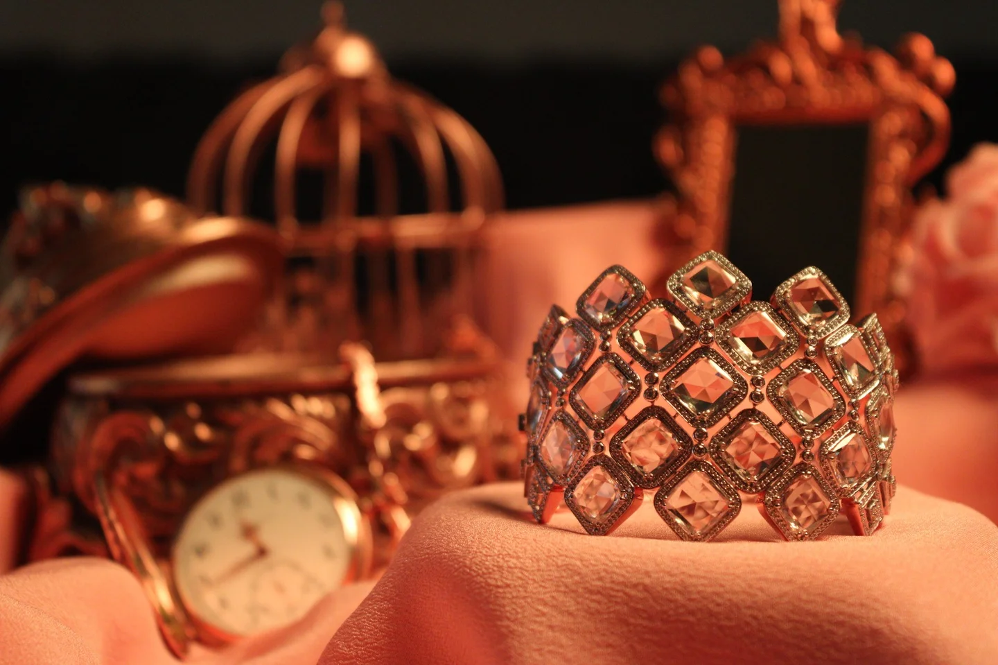 Sculptural jewellery, set against warm light.