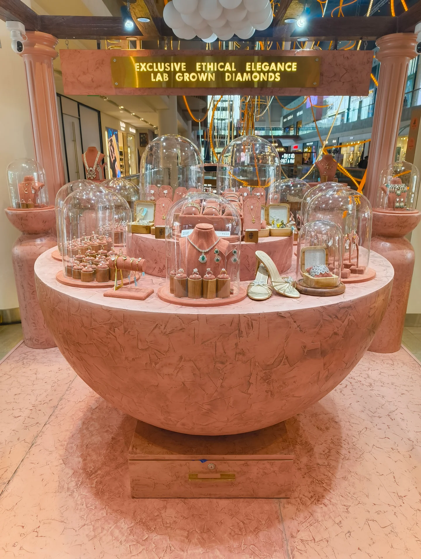 Jewellery arranged beneath glass cloches on a sculptural terracotta display island