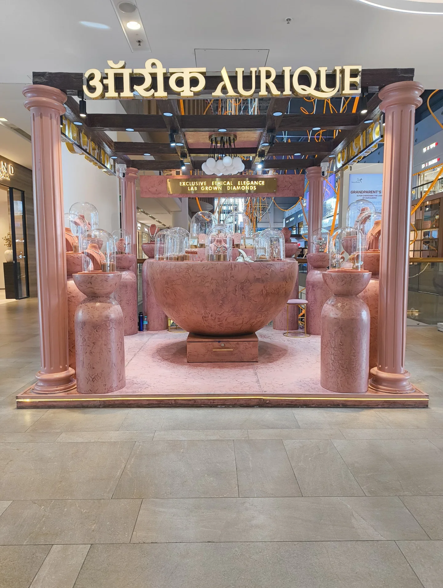 Aurique pavilion framed by pink columns beneath illuminated Aurique signs
